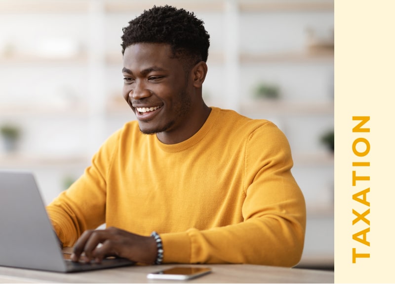 Young african-american man smiling while on laptop